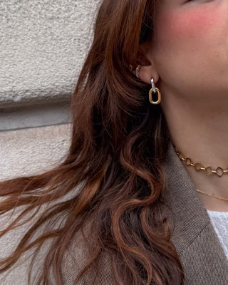 Argollas doradas cadena margarita en oreja de modelo, acero inoxidable Pialü