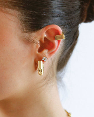 Detalle de aretes stud flor de circones plateados, waterproof de Pialü