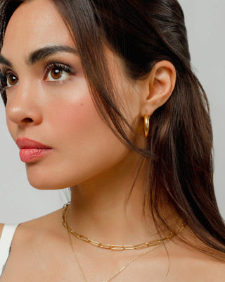 Argollas gota doradas gruesas en modelo con look elegante, waterproof de Pialü