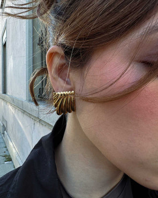 Vista lateral de aretes plateados rectangulares con estrías, waterproof de Pialü