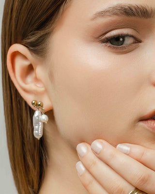 Modelo con pendientes Perla Joie dorados con perla, joya waterproof de Pialü