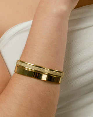 Brazalete dorado Golden rígido puesto en muñeca de modelo, joya waterproof de Pialü