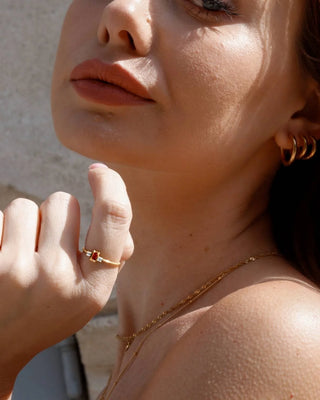 Anillo dorado con circonita roja baguette y piedras blancas detalle waterproof de Pialü