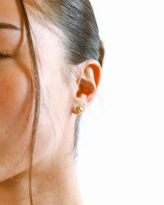 Par de aretes stud corazón dorado vistos de frente, acero inoxidable waterproof de Pialü