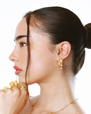 Argollas ovaladas doradas de perfil sobre fondo claro, waterproof de Pialü