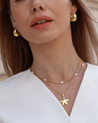 Detalle de collar dorado con perlas barrocas blancas en cadena cubana, joya waterproof Pialü