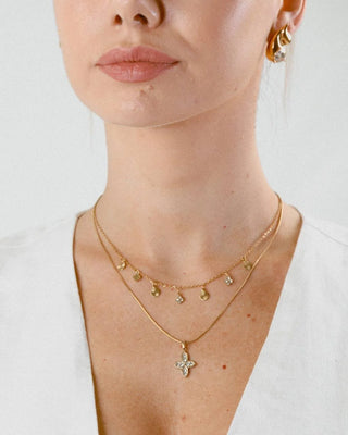 Collar amuleto dorado con perlas rojas en forma floral, vista frontal, Pialü