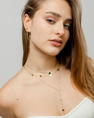 Collar fino dorado con dije de zircón esmeralda, vista lateral, waterproof de Pialü