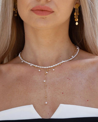 Detalle de collar dorado Y con mini perlas de vidrio blancas distribuidas, joya acero inoxidable Pialü