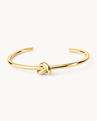 Pulsera rígida dorada con nudo central y extremos abiertos, waterproof de Pialü