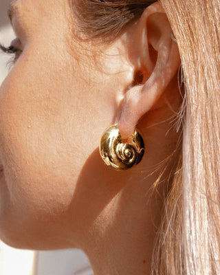 Aretes dorados en forma de caracola marina con espiral brillante usados en oreja, waterproof de Pialü