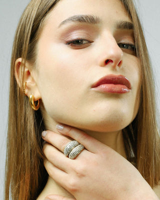 Anillo dorado con zircones estilo abombado lucido en mano, joya waterproof de Pialü