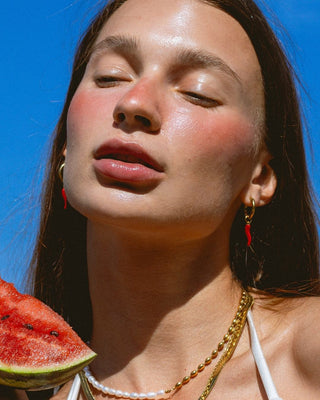Modelo con argollas de ají rojo doradas puestas, waterproof de Pialü