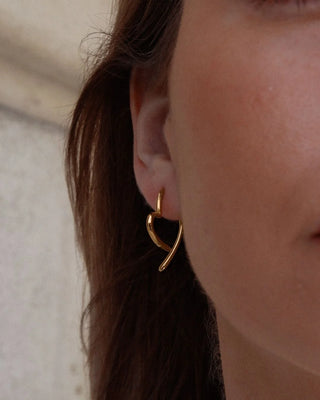 Aretes dorados forma corazón partido detalle close-up waterproof de Pialü