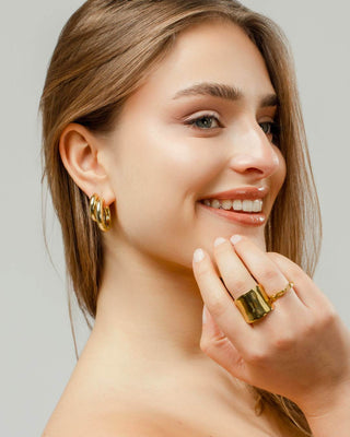 Argollas doradas minimal de Pialü puestas en oreja, dos pares de aros lisos, waterproof