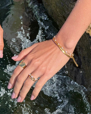Pulsera herringbone dorada plana sobre fondo blanco, acero inoxidable waterproof de Pialü