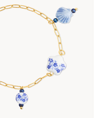 Pulsera dorada con charms de cerámica azul y blanco floral, joya waterproof de Pialü