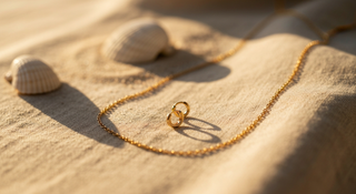 Cadena dorada sobre arena con conchas - joyas de verano waterproof