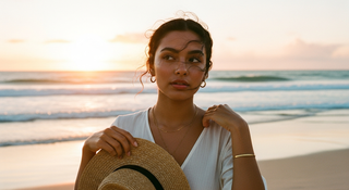 Mujer viajera con joyas doradas en playa tropical al atardecer