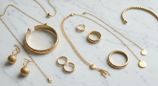 Joyas doradas y plateadas mezcladas sobre superficie de mármol - tendencia mixed metals 2026