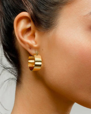 Argollas anchas doradas superficie lisa, detalle, waterproof de Pialü