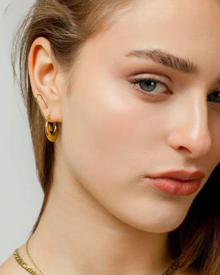 Argollas mini doradas Karmela puestas en oreja, joya waterproof Pialü