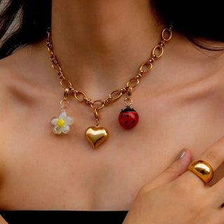 Charm CandyLand con flor nácar blanca, corazón dorado y vaquita roja, waterproof de Pialü