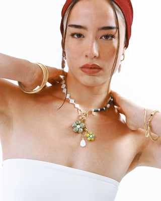 Detalle charm flor millefiori amarilla con perla en dorado, joya waterproof de Pialü