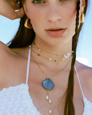 Detalle collar Calipso: concha azul marino pintada a mano con perlas blancas, Pialü