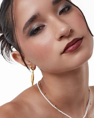 Aretes contracorriente dorados con argolla fina y pez colgante waterproof de Pialü