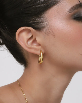 Aros dorados tipo argolla tubo gruesa vistos en oreja, joya waterproof de Pialü