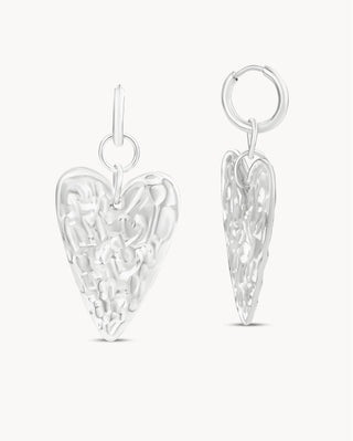 Aretes colgantes plateados forma corazón con textura relieve irregular y argolla, joya waterproof de Pialü