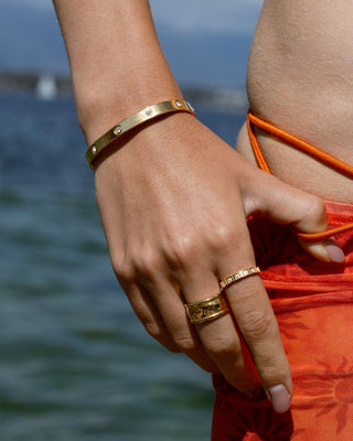 Modelo con brazalete dorado rígido con piedras brillantes, waterproof de Pialü