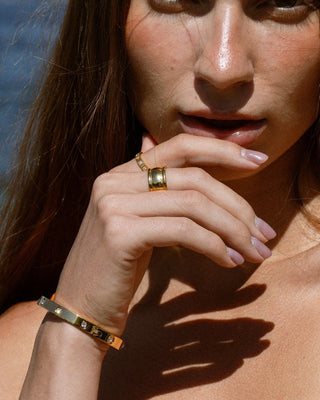 Modelo luciendo brazalete Amanda dorado con zircones, joya waterproof de Pialü