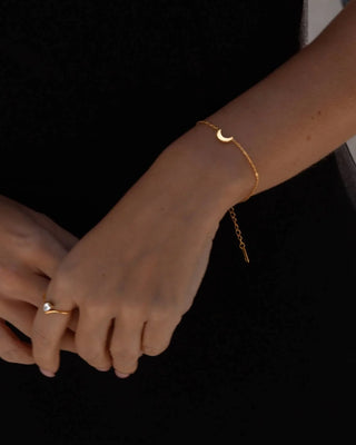 Detalle del dije luna creciente dorado en pulsera de cadena fina waterproof de Pialü