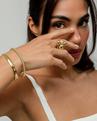 Tres pulseras doradas Rock Star apiladas: bangle, beaded y cuff, waterproof de Pialü